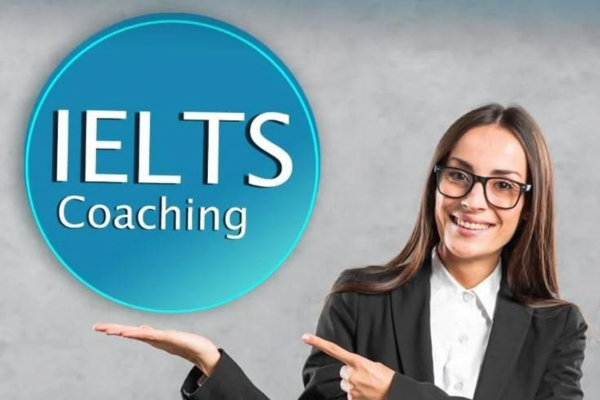 A woman wearing glasses holds an IELTS coaching sign, smiling and promoting language learning opportunities.
